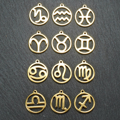 Zwölf goldfarbene, glänzende, runde Anhänger mit durchbrochenen Sternzeichen-Symbolen in feinem Metallrahmen, jeweils mit kleiner Öse oben.