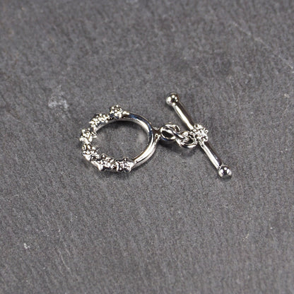 Knebel Verschluss oval, Kupfer rhodiniert, Blütenmotiv, 11042