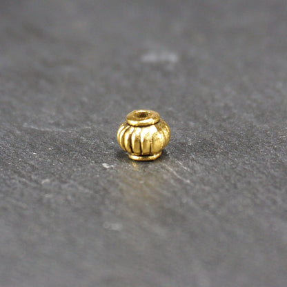10 kleine Perlen 4mm, geriffelt, Barrel, antik goldfarben, 10469