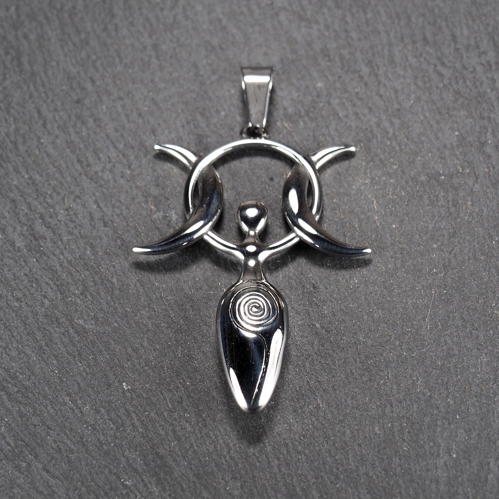 Anhänger aus poliertem silberfarbenem Edelstahl in figürlicher Form mit durchbrochenem Dreifachmond-Motiv, Spirale und Anhängerschlaufe.