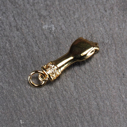 Goldfarbener Anhänger in Figa-Hand-Form mit glänzender Oberfläche, fein gravierter ornamentaler Manschette und kleiner Anhängeröse.
