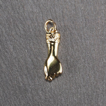 Goldfarbener Anhänger in Figa-Hand-Form mit glänzender Oberfläche, fein gravierter ornamentaler Manschette und kleiner Anhängeröse.