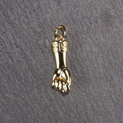 Goldfarbener Anhänger in Figa-Hand-Form mit glänzender Oberfläche, fein gravierter ornamentaler Manschette und kleiner Anhängeröse.