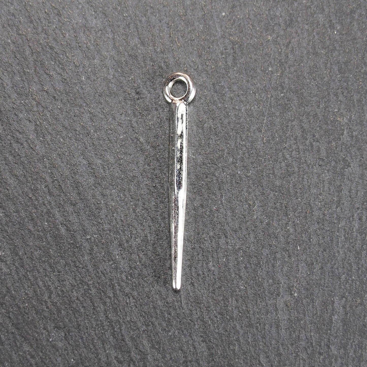Kegelanhänger aus silberfarbenem Metall, konisch spitz zulaufend mit quadratischem Querschnitt, glatte glänzende Oberfläche und rundes Ösenauge.