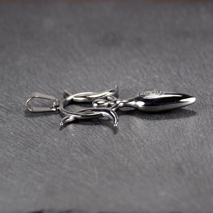 Anhänger aus poliertem silberfarbenem Edelstahl in figürlicher Form mit durchbrochenem Dreifachmond-Motiv, Spirale und Anhängerschlaufe.