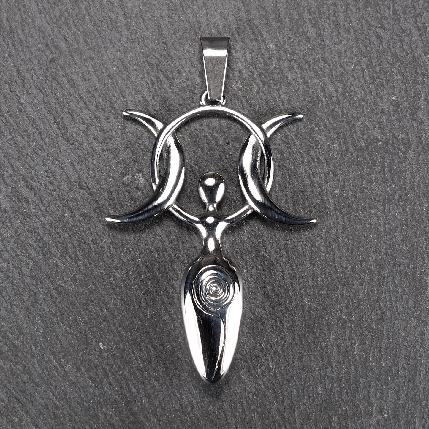 Anhänger aus poliertem silberfarbenem Edelstahl in figürlicher Form mit durchbrochenem Dreifachmond-Motiv, Spirale und Anhängerschlaufe.