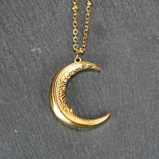 Vergoldeter Mondsichel-Anhänger mit filigraner Gravur und durchbrochener Silhouette an feiner Satellitenkette.