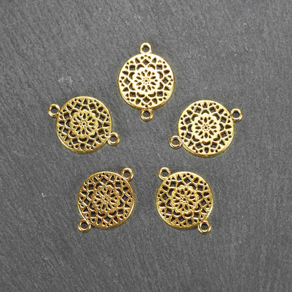 Fünf runde goldfarbene Verbinder mit durchbrochenem, radial-symmetrischem Mandala- bzw. Blütenmuster und je zwei Ösen.