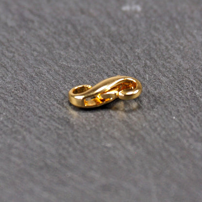 Karabiner in liegender Acht, goldfarbenes glänzendes Metall mit glatter Oberfläche, zwei gegenüberliegende Öffnungen und sichtbaren Ringösen.
