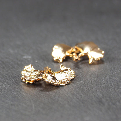 Anhänger, vergoldet und glänzend, in Form dreigeteilter Ginkgo-Blätter mit reliefartiger Struktur und sichtbaren Blattadern, oben kleine Öse.