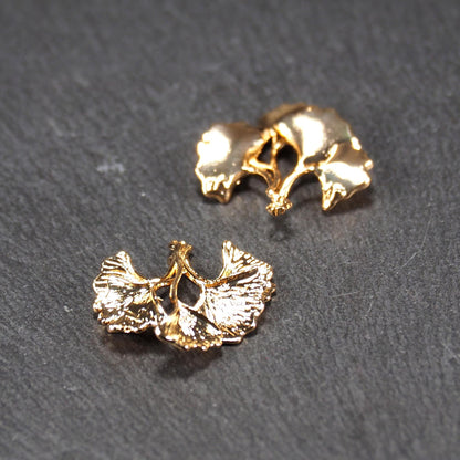 Anhänger, vergoldet und glänzend, in Form dreigeteilter Ginkgo-Blätter mit reliefartiger Struktur und sichtbaren Blattadern, oben kleine Öse.