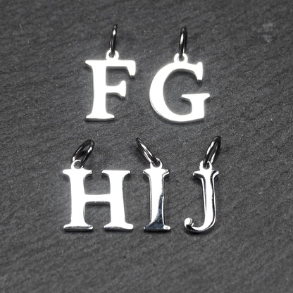 Buchstaben-Anhänger aus silberfarbenem, poliertem Metall, serifenförmige Großbuchstaben F, G, H, I, J mit kleinen Ösen.