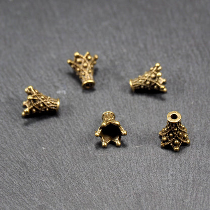 Fünf konische bronzefarbenen Perlenkappe naus Metall mit filigranem Ornamentreliéf, kugeligen Verzierungen und zentralem Fädelloch.