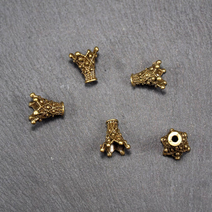 Fünf konische bronzefarbenen Perlenkappe naus Metall mit filigranem Ornamentreliéf, kugeligen Verzierungen und zentralem Fädelloch.