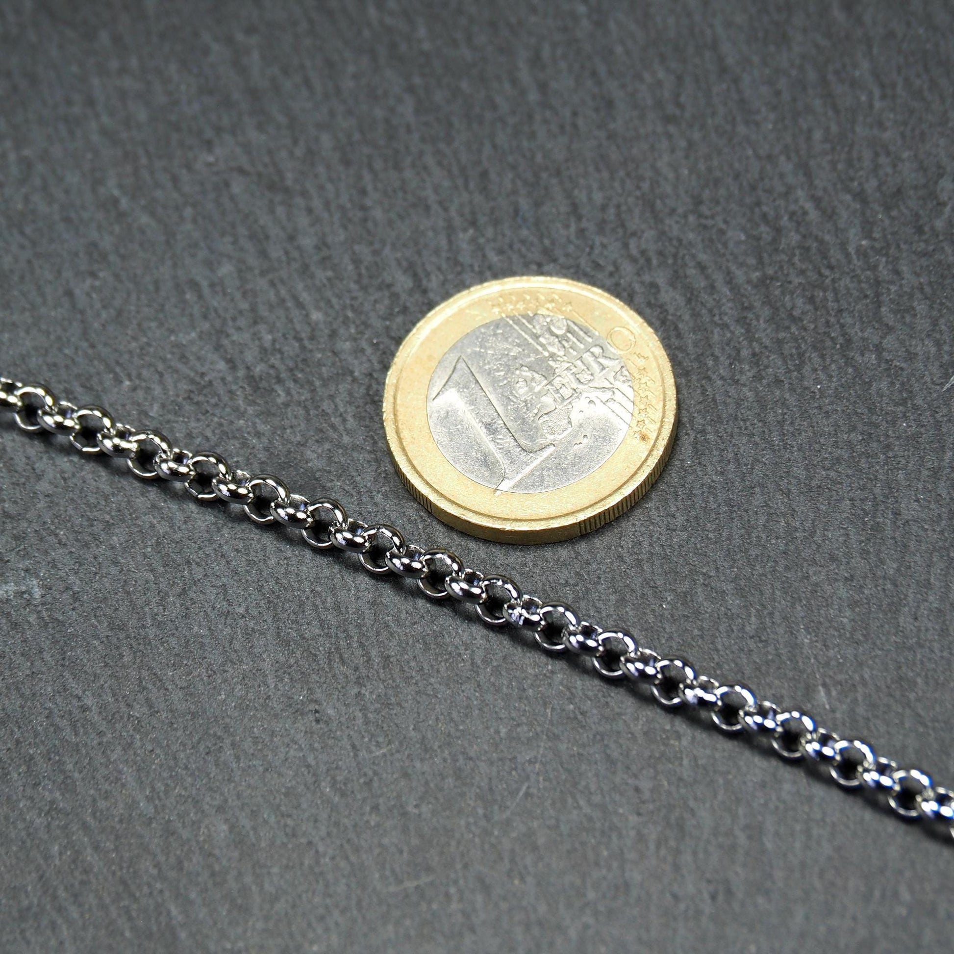 Silberglänzende Rolokette mit runden, gleichmäßigen Gliedern. 1 Euro Münze zum Größenvergleich.
