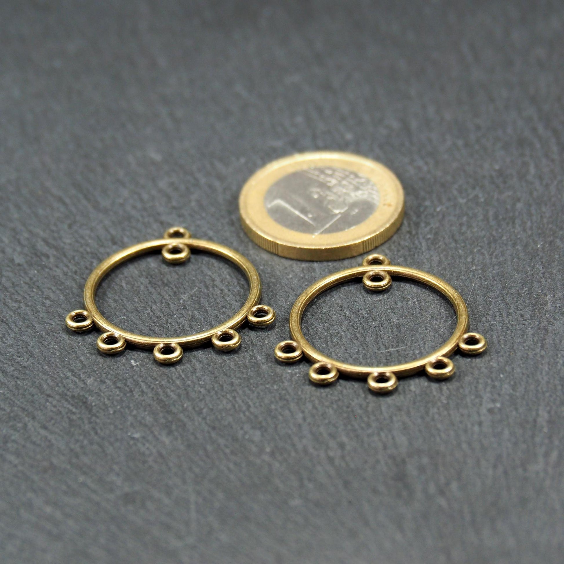 Zwei runde Chandelier-Verbinder aus antik bronzefarbenem Metall, je mit einer oberen Öse und fünf gleichmäßig angeordneten unteren Ösen.