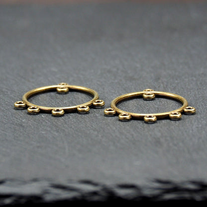 Zwei runde Chandelier-Verbinder aus antik bronzefarbenem Metall, je mit einer oberen Öse und fünf gleichmäßig angeordneten unteren Ösen.