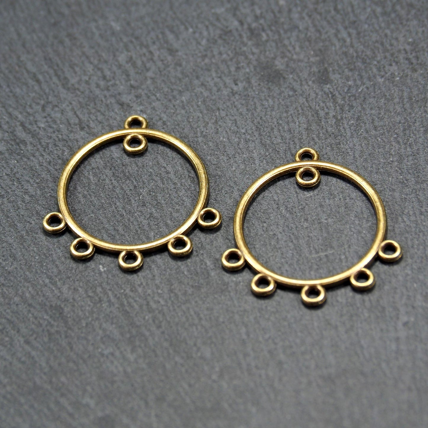 Zwei runde Chandelier-Verbinder aus antik bronzefarbenem Metall, je mit einer oberen Öse und fünf gleichmäßig angeordneten unteren Ösen.