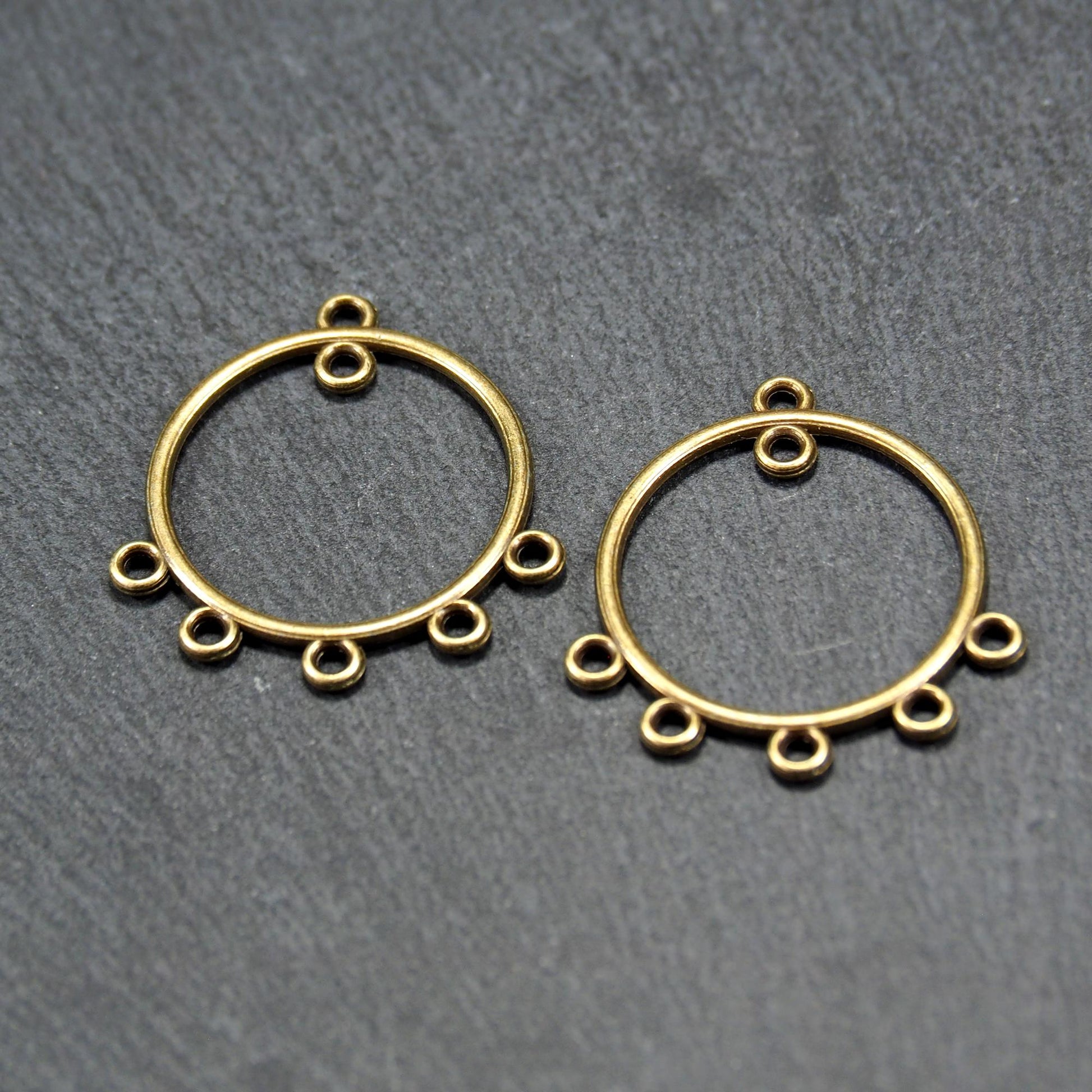 Zwei runde Chandelier-Verbinder aus antik bronzefarbenem Metall, je mit einer oberen Öse und fünf gleichmäßig angeordneten unteren Ösen.