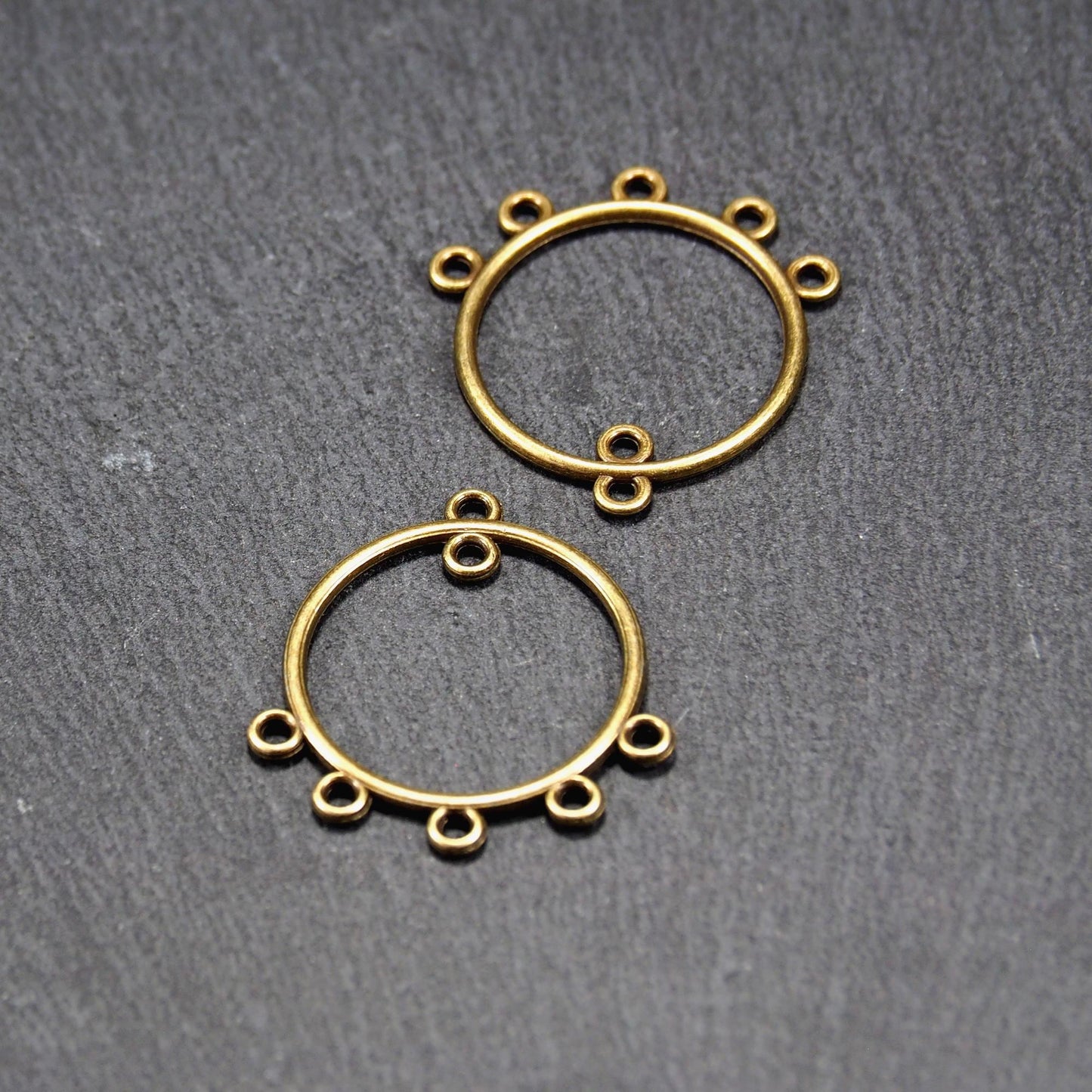 Zwei runde Chandelier-Verbinder aus antik bronzefarbenem Metall, je mit einer oberen Öse und fünf gleichmäßig angeordneten unteren Ösen.