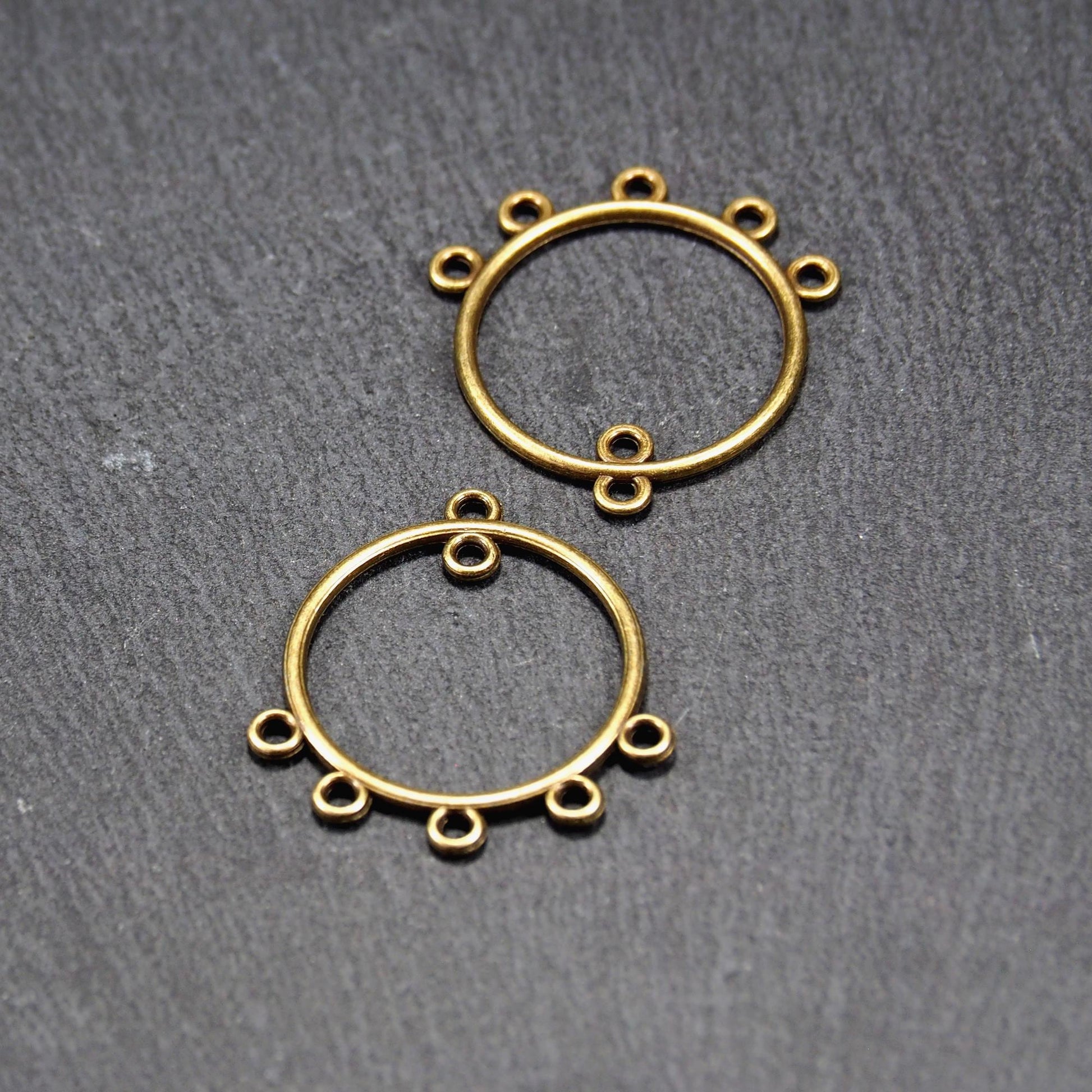 Zwei runde Chandelier-Verbinder aus antik bronzefarbenem Metall, je mit einer oberen Öse und fünf gleichmäßig angeordneten unteren Ösen.