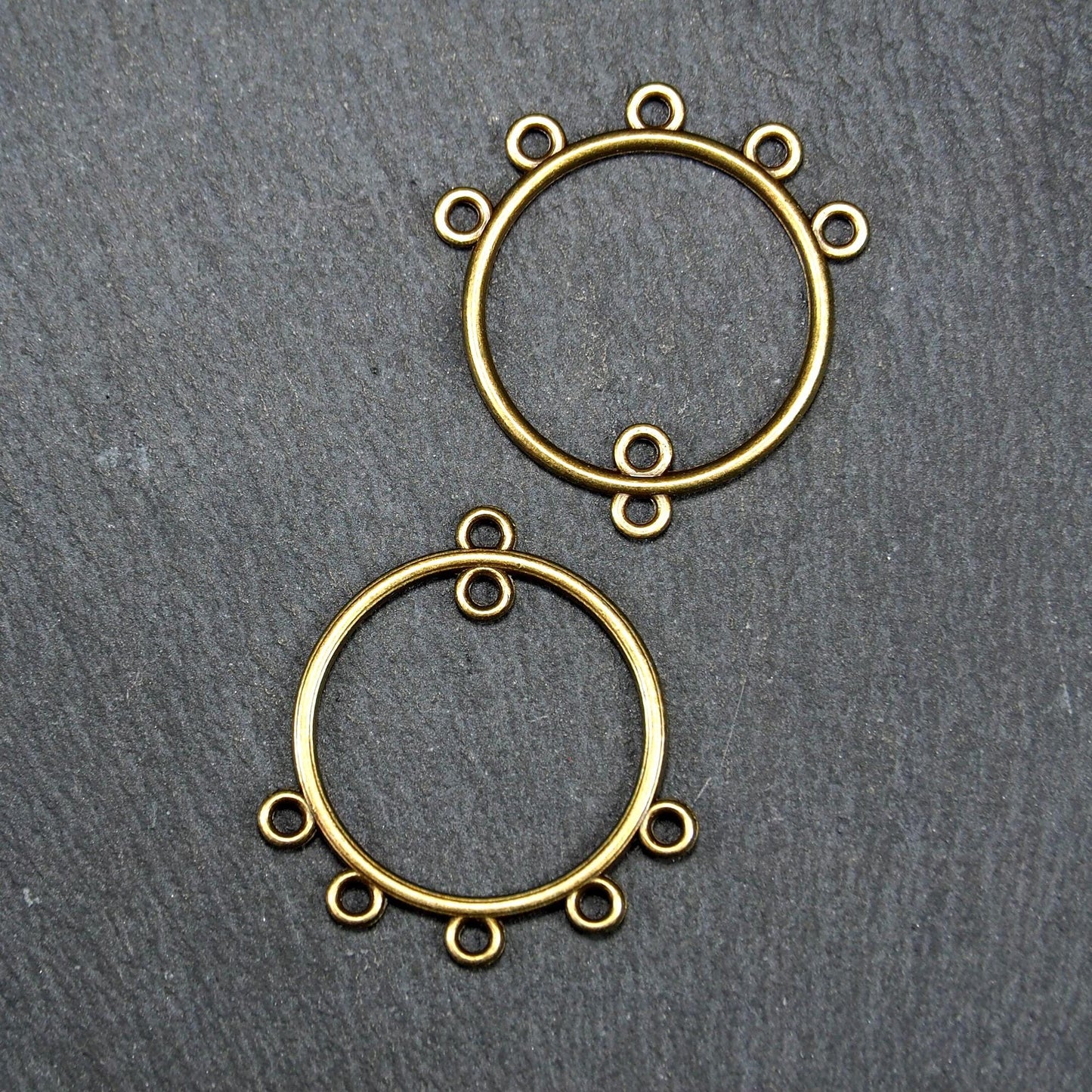 Zwei runde Chandelier-Verbinder aus antik bronzefarbenem Metall, je mit einer oberen Öse und fünf gleichmäßig angeordneten unteren Ösen.