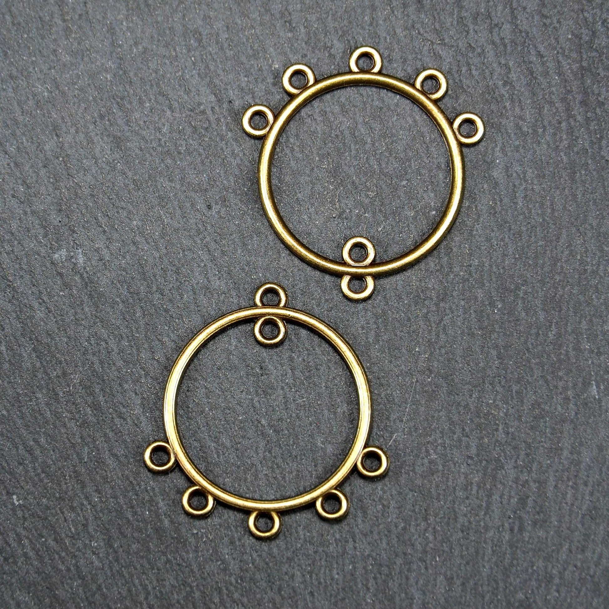 Zwei runde Chandelier-Verbinder aus antik bronzefarbenem Metall, je mit einer oberen Öse und fünf gleichmäßig angeordneten unteren Ösen.