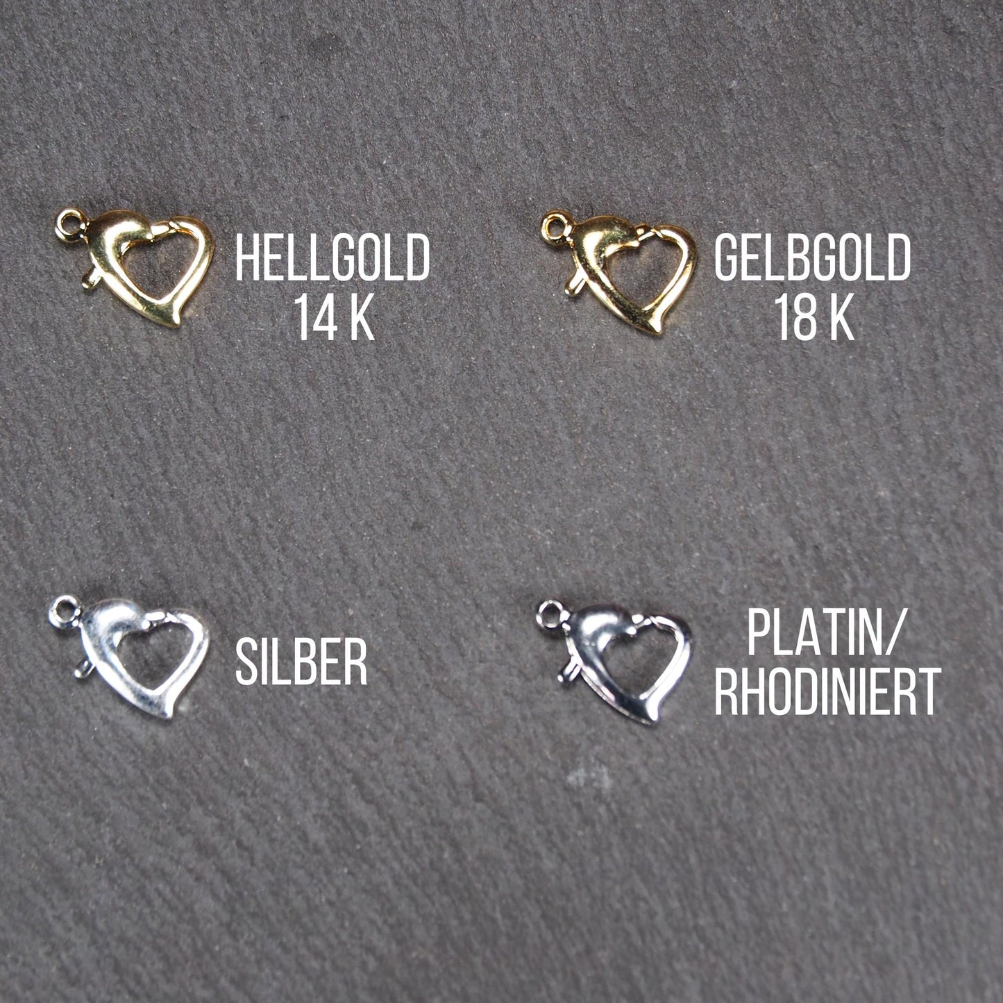 Herzförmiger Karabiner-Verschluss, filigrane durchbrochene offene Herzform mit sichtbarer Anhängeröse, jeweils in Hellgold, Gelbgold, Silber und rhodiniert.