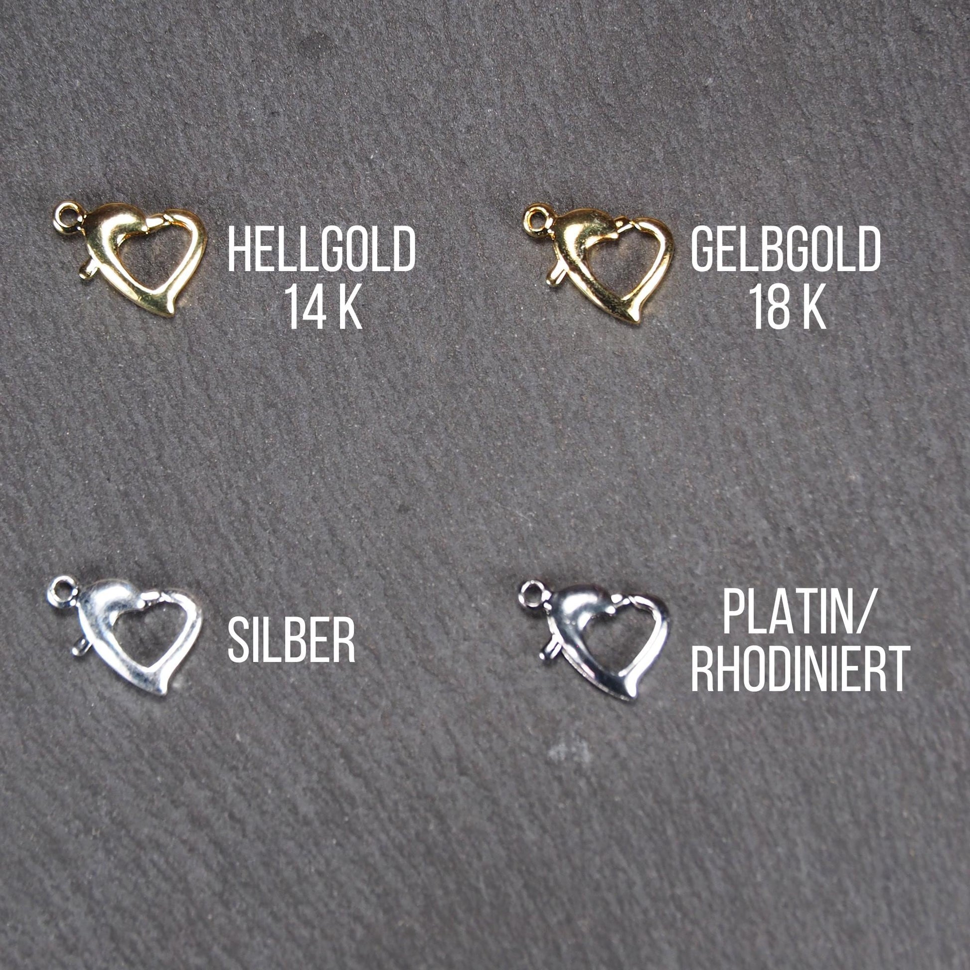 Herzförmiger Karabiner-Verschluss, filigrane durchbrochene offene Herzform mit sichtbarer Anhängeröse, jeweils in Hellgold, Gelbgold, Silber und rhodiniert.