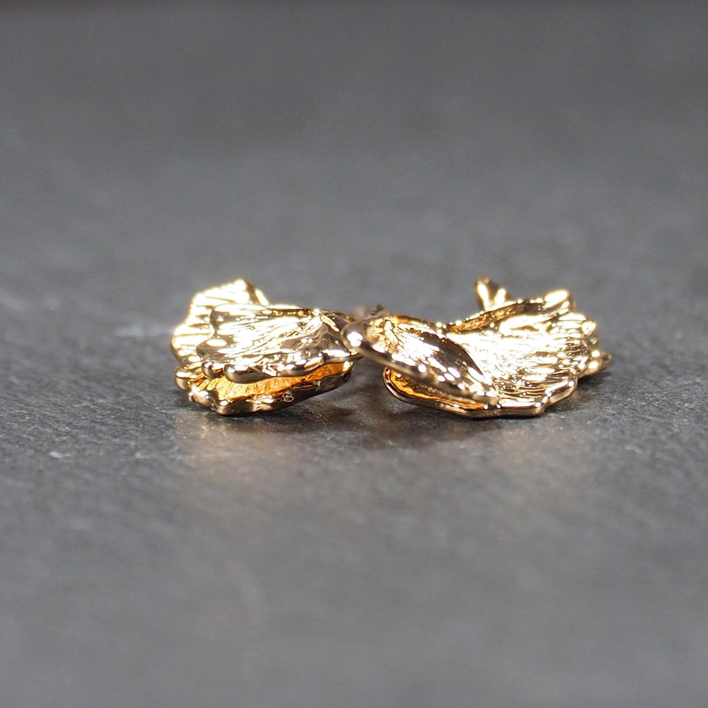 Anhänger, vergoldet und glänzend, in Form dreigeteilter Ginkgo-Blätter mit reliefartiger Struktur und sichtbaren Blattadern, oben kleine Öse.