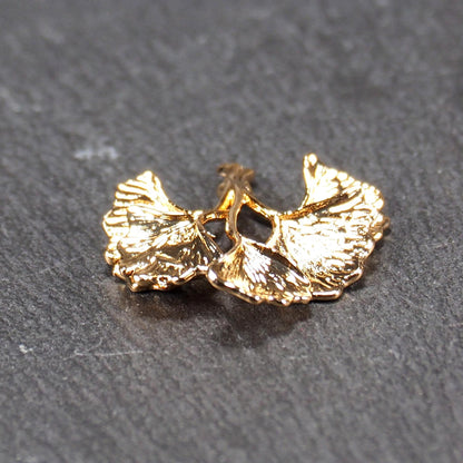 Anhänger, vergoldet und glänzend, in Form dreigeteilter Ginkgo-Blätter mit reliefartiger Struktur und sichtbaren Blattadern, oben kleine Öse.