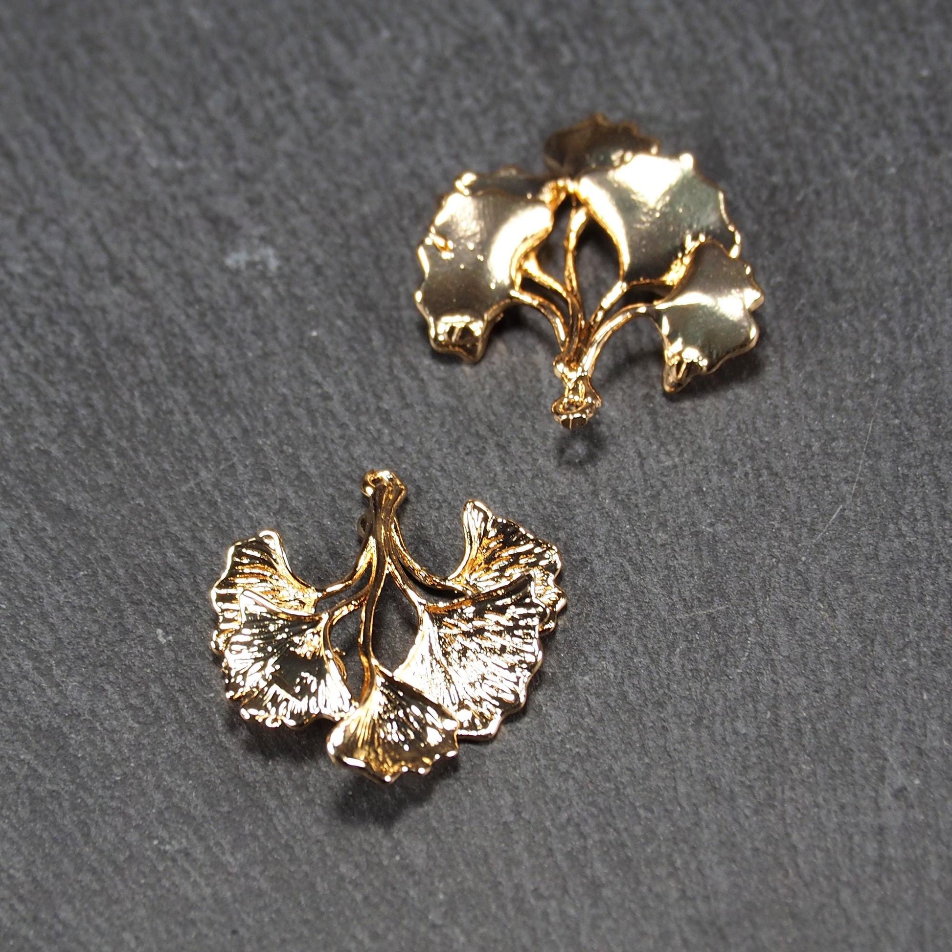 Anhänger, vergoldet und glänzend, in Form dreigeteilter Ginkgo-Blätter mit reliefartiger Struktur und sichtbaren Blattadern, oben kleine Öse.