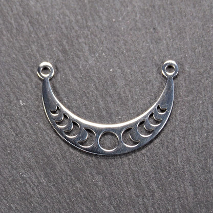 Sichelförmiger silberner Metallverbinder mit ausgeschnittenem Mondphasen-Motiv und je einer Rundöse an den Enden.