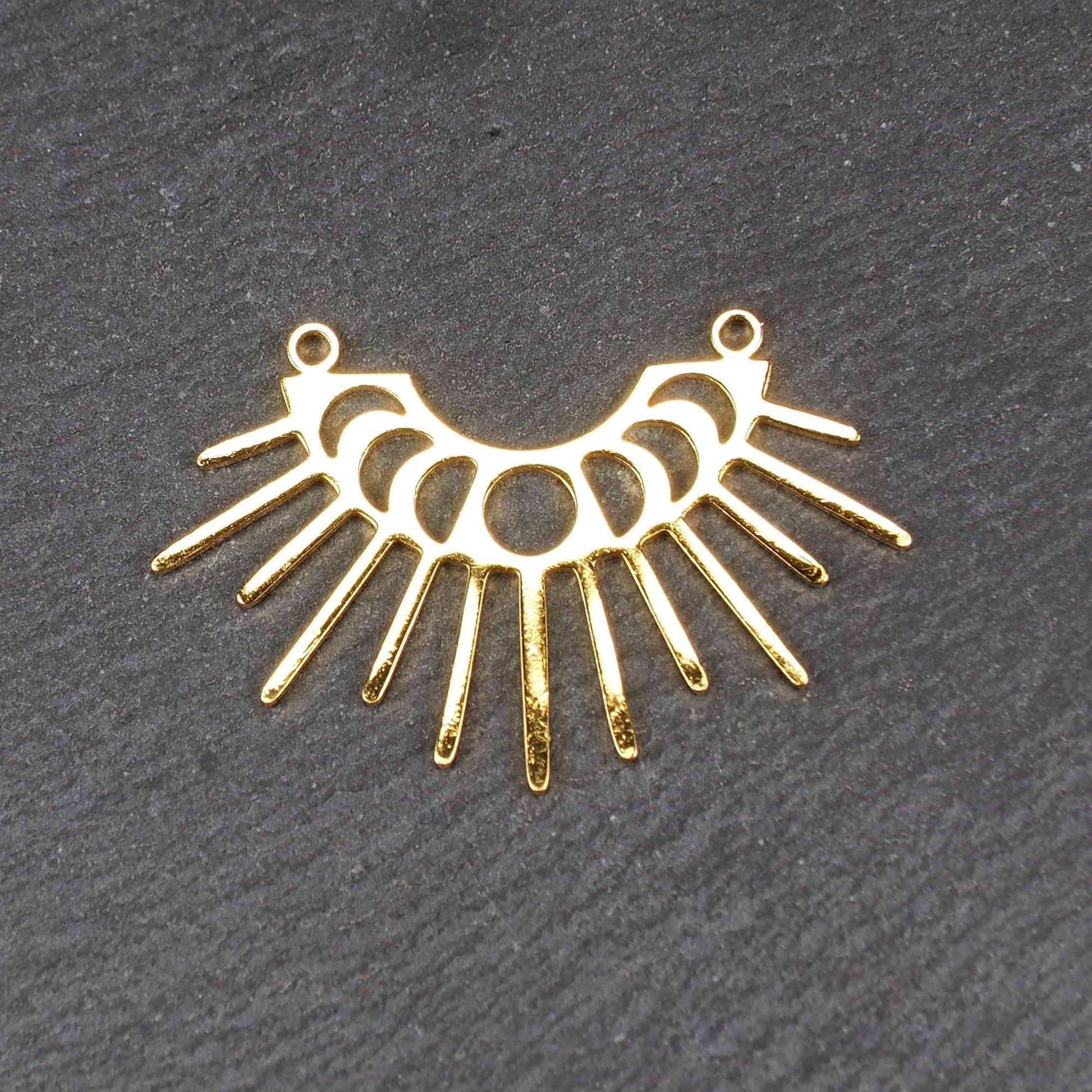 Verbinder, goldfarben glänzend, halbkreisförmig mit durchbrochenen Mondphasen und ausstrahlenden Sonnenstrahlen, oben zwei Ösen.