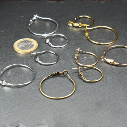 Runde Klapp-Creolen in silber, platin, hellgold, gelbgold und bronze mit Klappverschluss und glatter, glänzender Oberfläche, jeweils in zwei Größen. Mit 1 Euro Münze zum Größenvergleich.