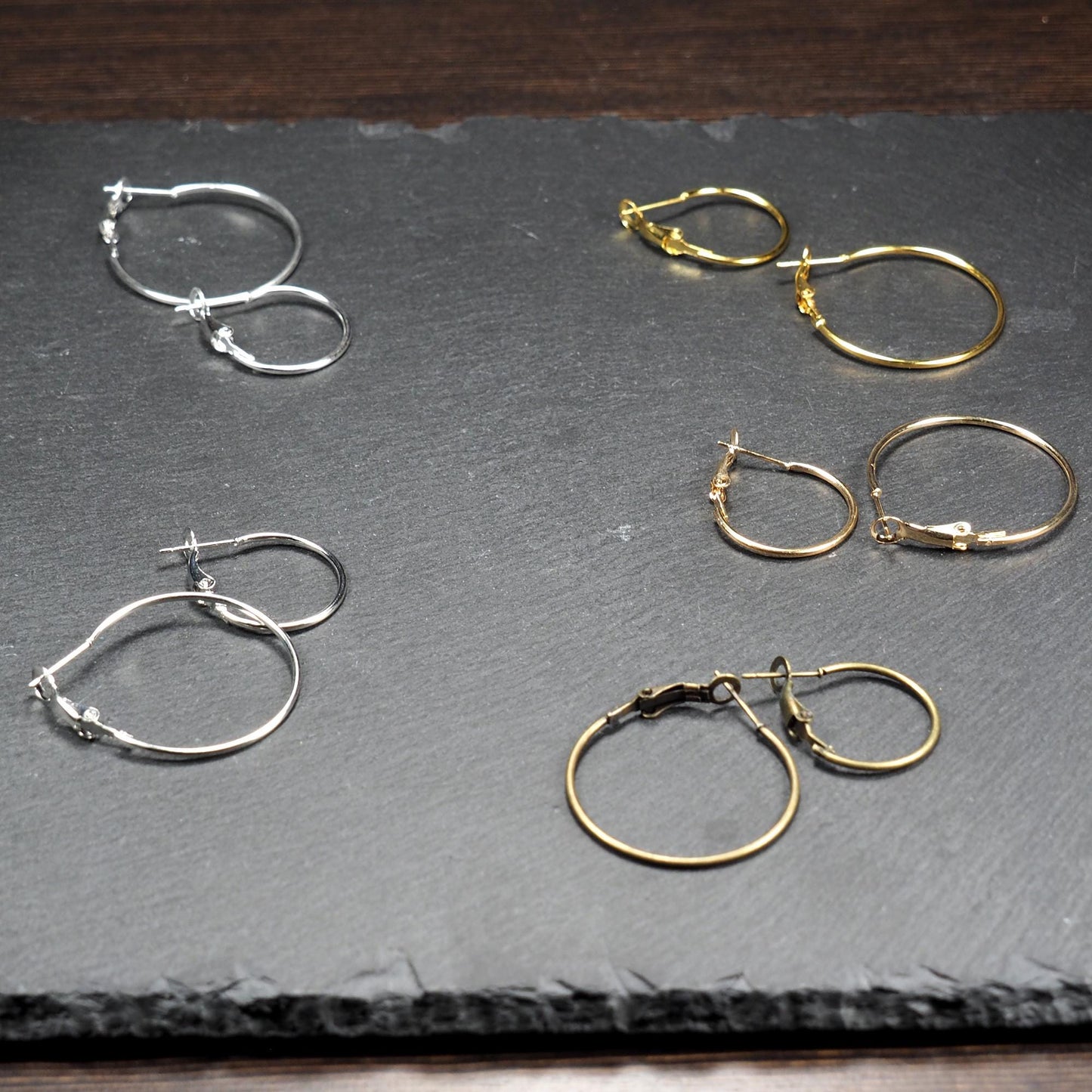 Runde Klapp-Creolen in silber, platin, hellgold, gelbgold und bronze mit Klappverschluss und glatter, glänzender Oberfläche, jeweils in zwei Größen.