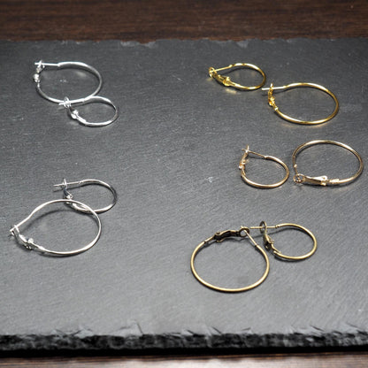 Runde Klapp-Creolen in silber, platin, hellgold, gelbgold und bronze mit Klappverschluss und glatter, glänzender Oberfläche, jeweils in zwei Größen.