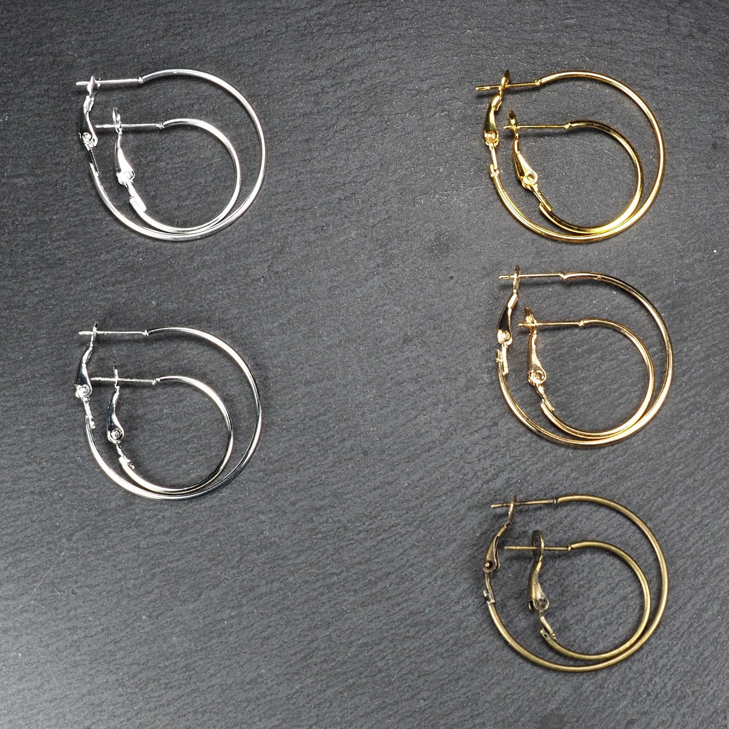 Runde Klapp-Creolen in silber, platin, hellgold, gelbgold und bronze mit Klappverschluss und glatter, glänzender Oberfläche, jeweils in zwei Größen.