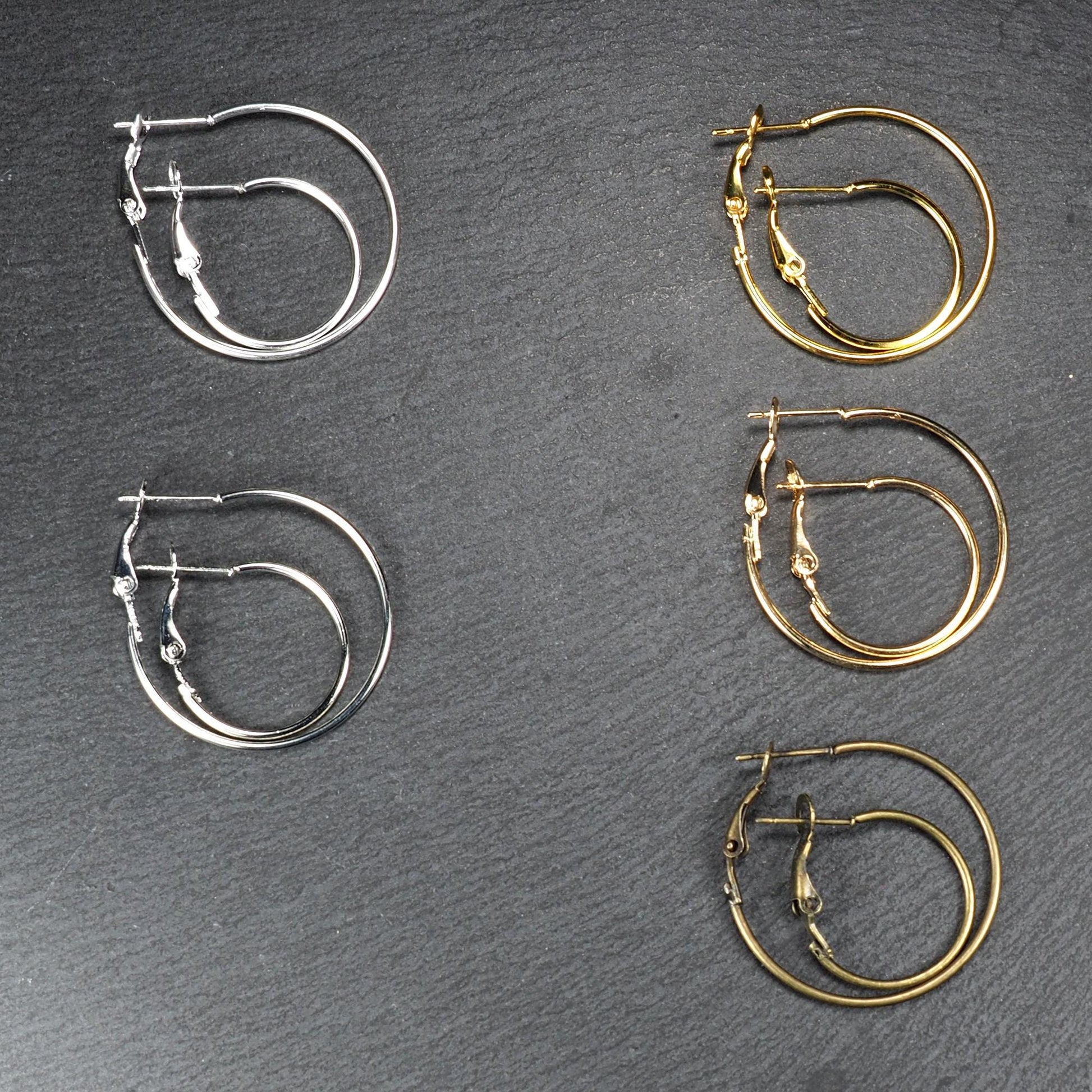 Runde Klapp-Creolen in silber, platin, hellgold, gelbgold und bronze mit Klappverschluss und glatter, glänzender Oberfläche, jeweils in zwei Größen.