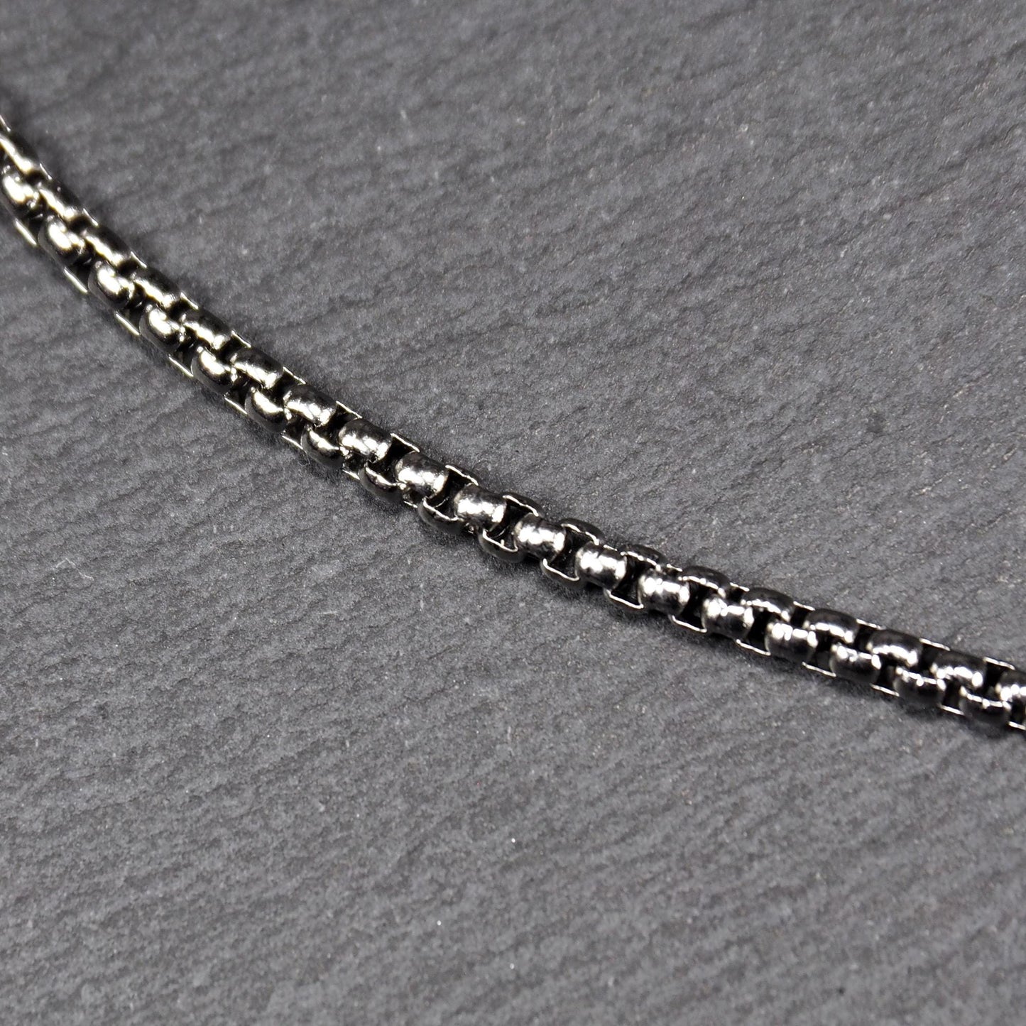 Keltischer, vierblättriger, durchbrochener Anhänger in silberner, glänzender Optik an einer quadratischen Boxkette mit Karabiner.