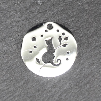 Runder, flacher Anhänger aus poliertem Edelstahl, Cut-out mit sitzender Katzen-Silhouette und Blattzweig, Öse oben und mehrere kleine Bohrungen.