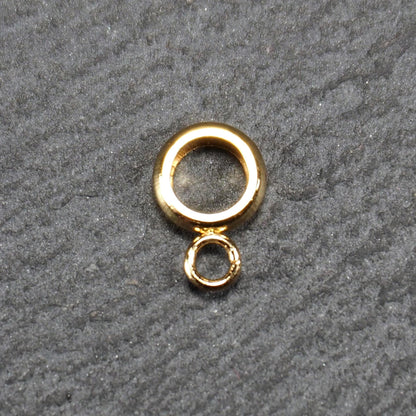 Ringförmige, glänzend goldfarbene Anhängeröse mit großem runden Loch und kleiner runder Anhängerschlaufe.