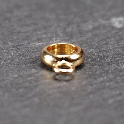 Ringförmige, glänzend goldfarbene Anhängeröse mit großem runden Loch und kleiner runder Anhängerschlaufe.