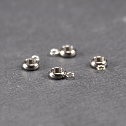 Vier glänzende silberfarbene runde Anhängerösen, jeweils ein größerer hohler Ring mit einer kleineren beweglichen Ringöse.