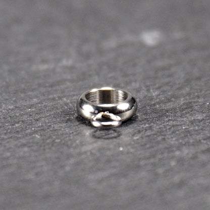 Anhängeröse, silberfarbene glänzende Metallrundung mit zentraler Öffnung und einer kleineren beweglichen Ringöse als Verbindungselement.