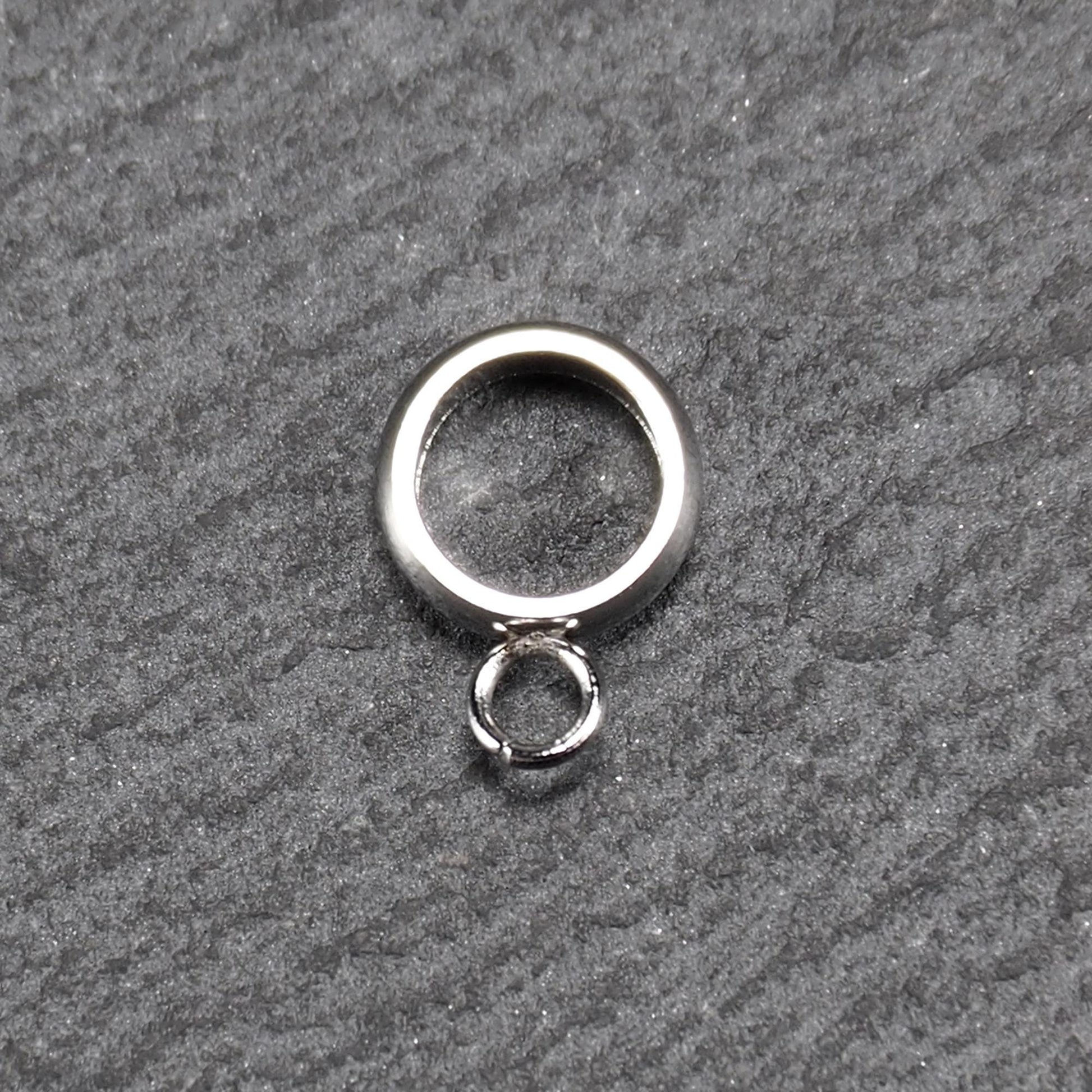 Runder, poliert glänzender silberfarbener Anhängerring mit großem Innenkreis und einer kleineren, unten befestigten Öse.
