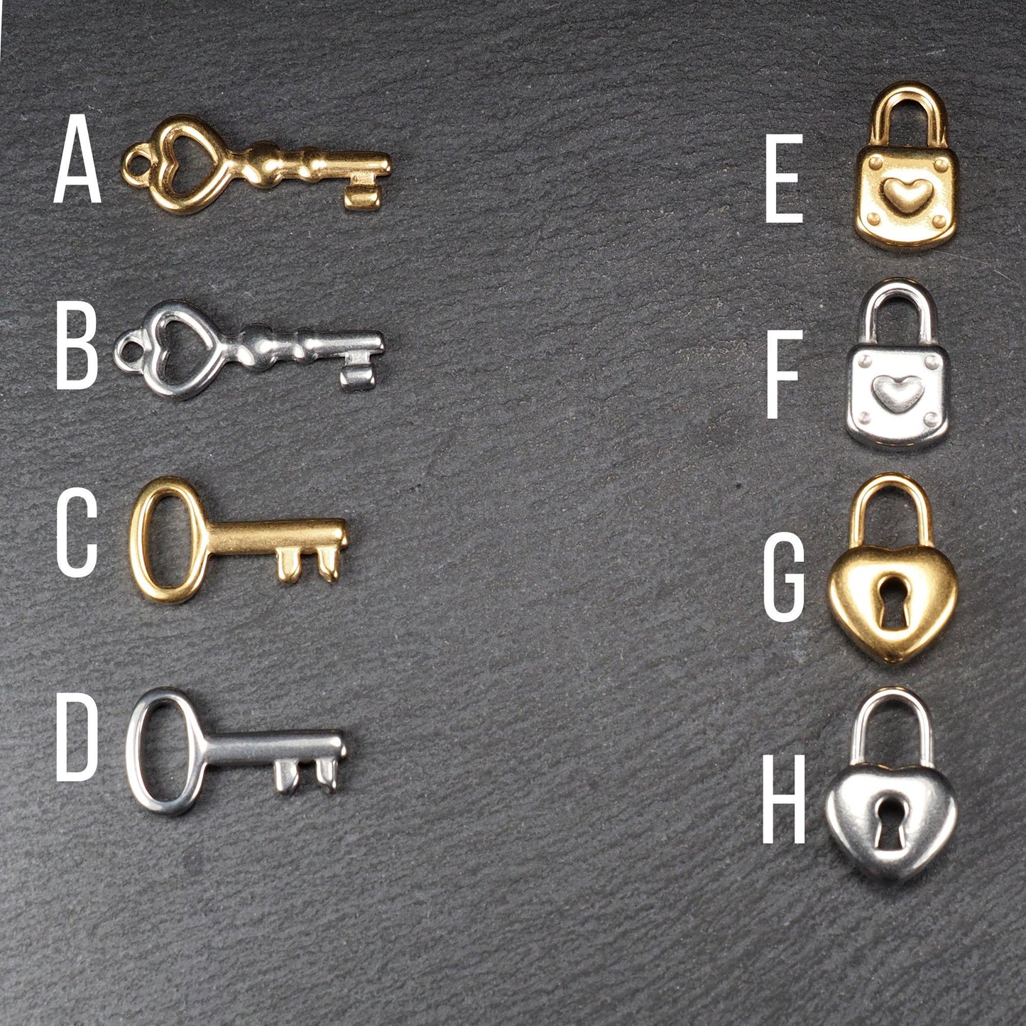 Acht Metallanhänger (Schlüssel und Schlösser), silber- oder goldfarben, glatte Oberfläche; Schlüssel mit herz- oder ovaler Öse, Schlösser quadratisch oder herzförmig mit Bügel.