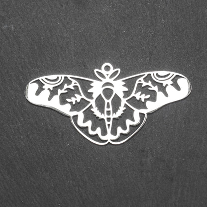 Anhänger / Verbinder in Mottenform aus poliertem silberfarbenem Edelstahl, filigranes durchbrochenes Ornament-Flügeldesign mit integrierter Öse oben.