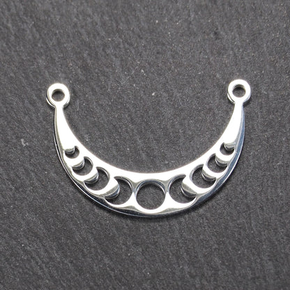 Sichelförmiger silberner Metallverbinder mit ausgeschnittenem Mondphasen-Motiv und je einer Rundöse an den Enden.