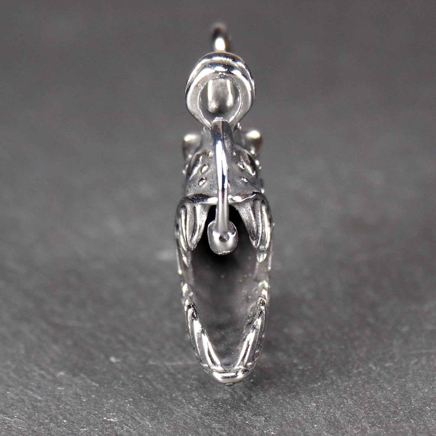 3D-Anhänger Anglerfisch, silberglänzend, mit geöffnetem Maul und dolchartigen Zähnen, geriffelten Flossen, punktiertem Körper und Öse.